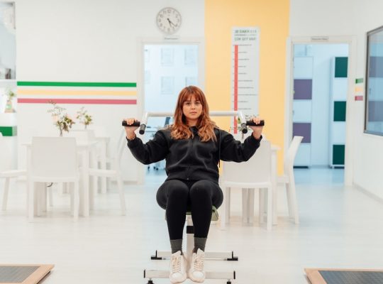 a woman sitting on top of a machine in a room